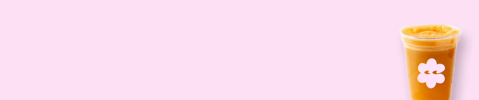 Plastikbecher mit orangefarbenem Saft vor einem rosa Hintergrund.