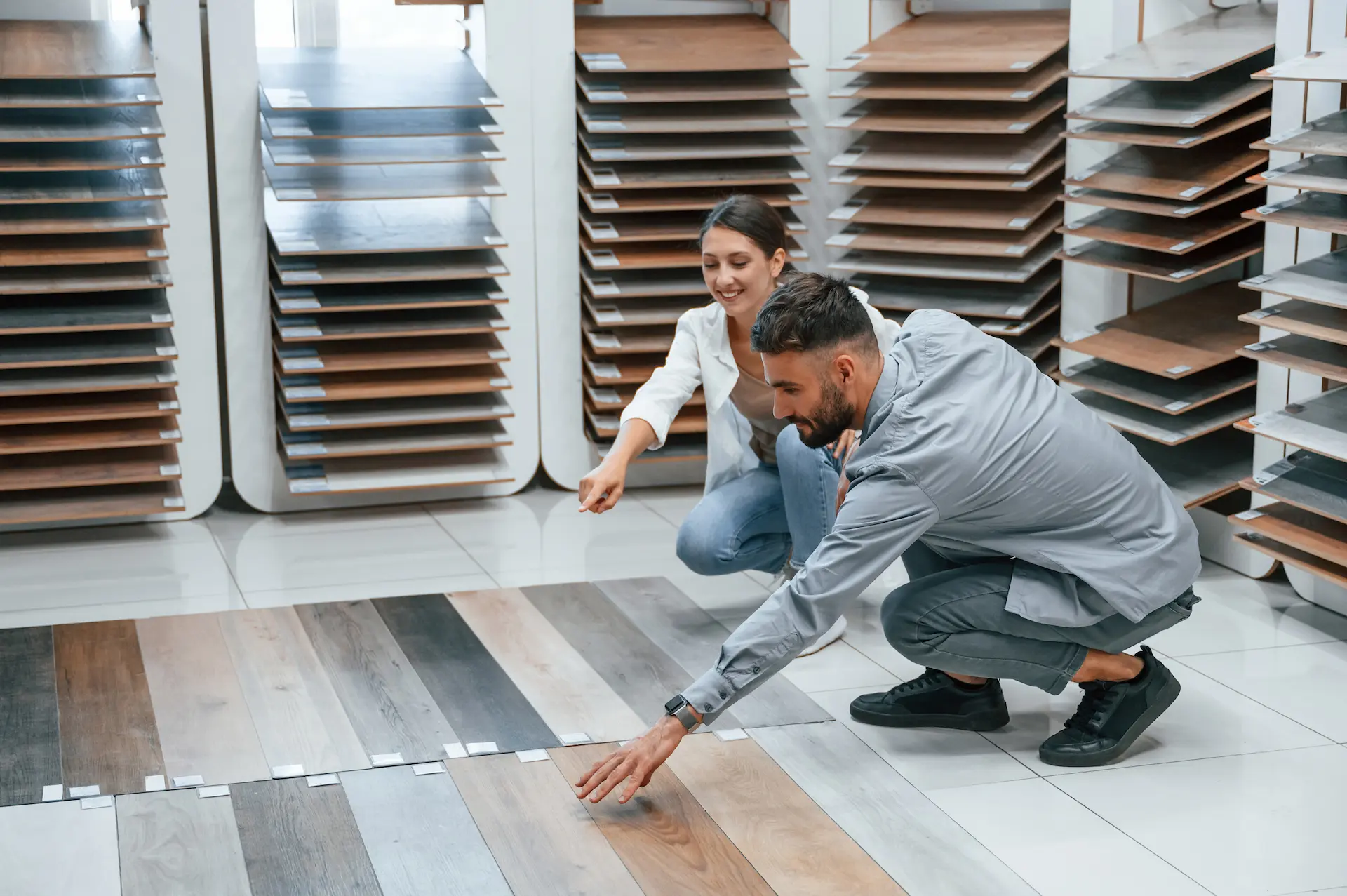 Un homme et une femme choisissent un modèle de parquet dans un showroom spécialisé