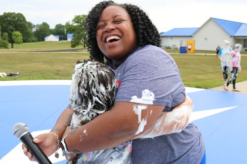 Staff hugging camper during outside activity