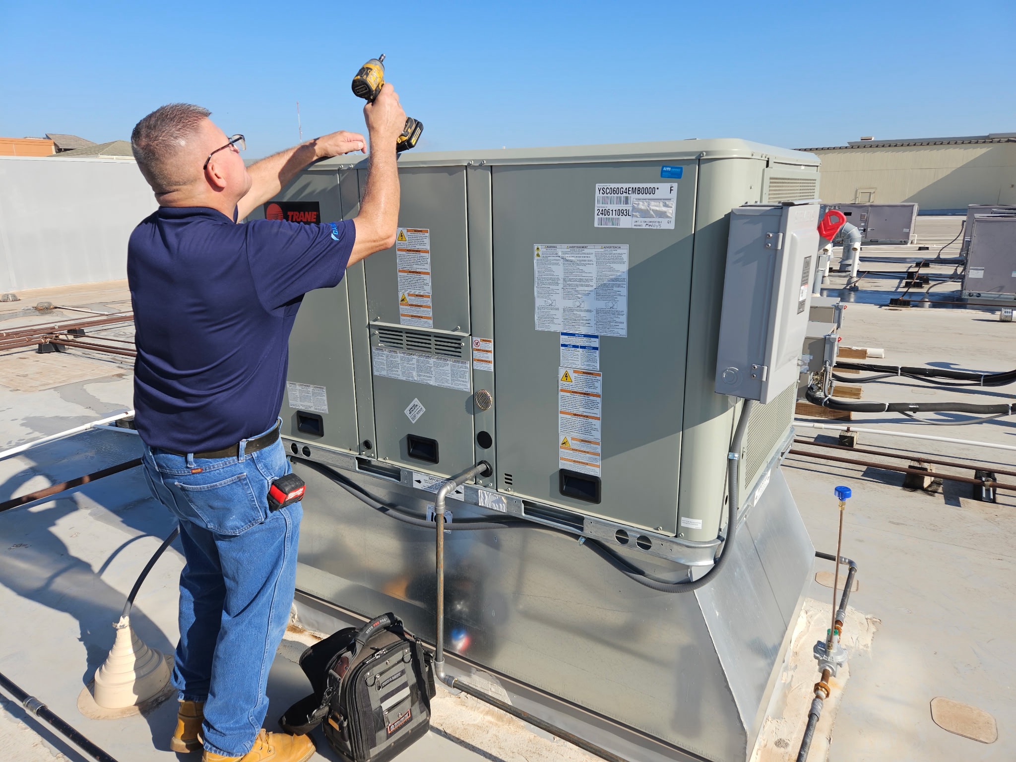HVAC Technician Servicing Rooftop Heating And Cooling Unit