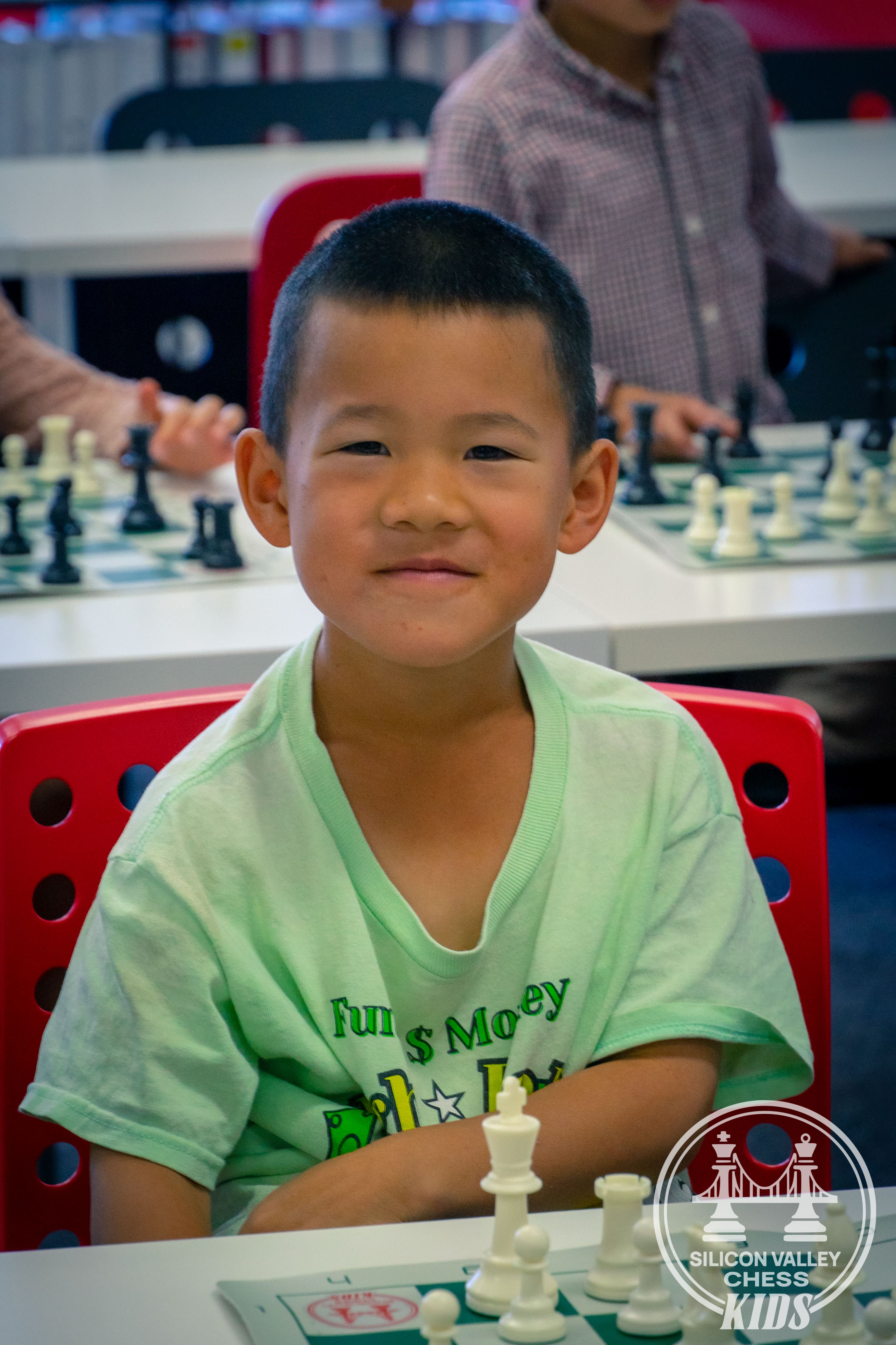 Kids attending interactive chess lesson at SVC Kids classroom with blue wall and demo board