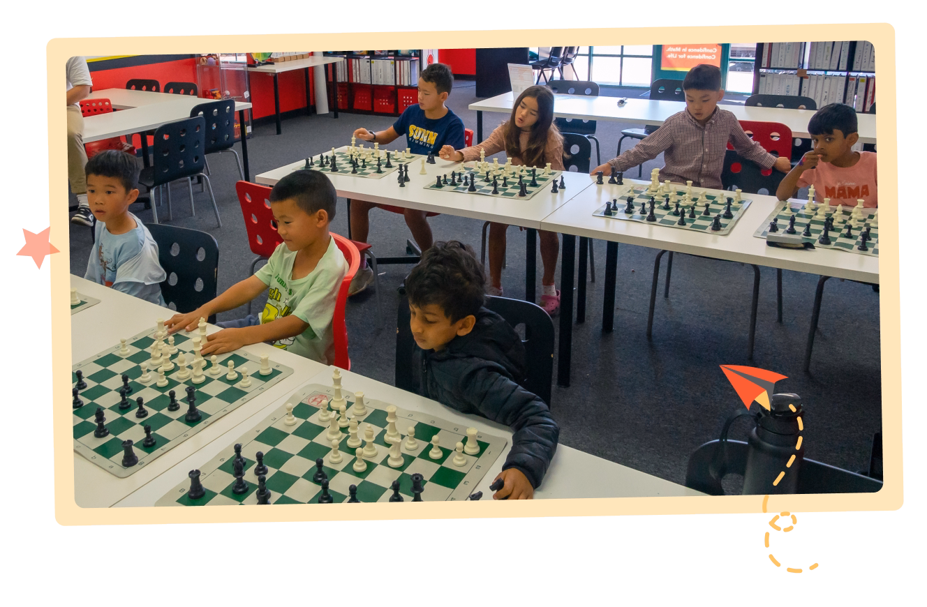 Children sitting in a classroom engaged in a chess lesson.