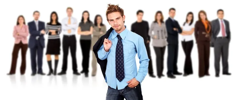 Business team standing over a white background with a young entrepreneur standing out from the crowd in front