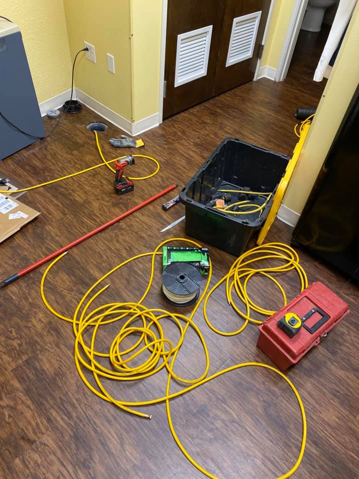 Plumbing tools and yellow inspection cables laid out for leak detection work indoors.