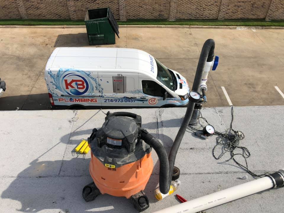 Plumbing van and equipment on a rooftop, likely for sump pump service.
