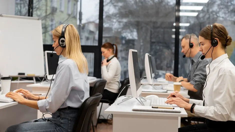 AI customer service agents in a call center using headsets and computers.