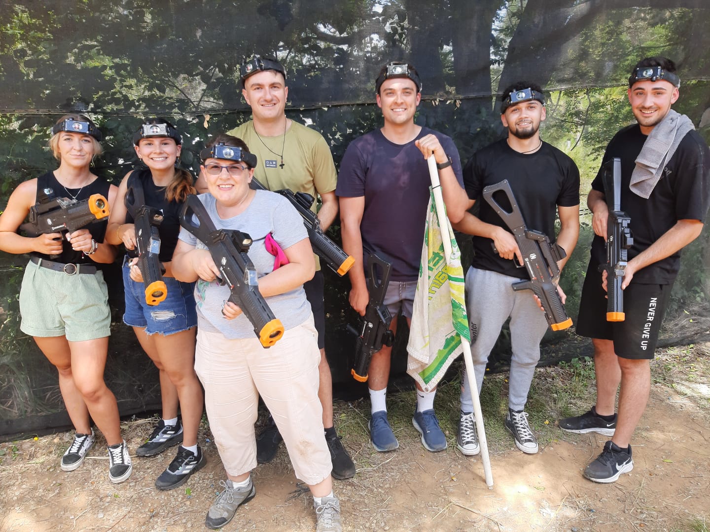 Person with blonde hair in a dark hoodie working on a laptop at a white desk with a plant, water bottle, and keyboard at Tecbot.