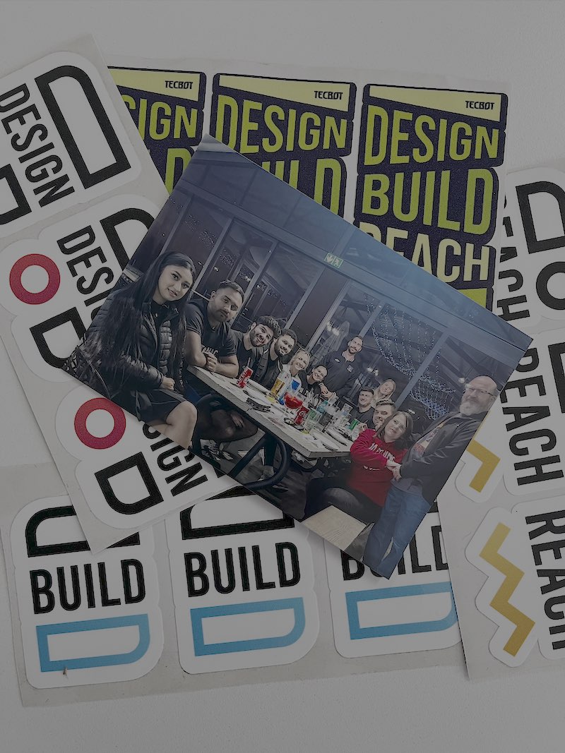 3D Tecbot logo. Three transparent glass petals arranged in a triangular shape casting soft shadows on a gray background.