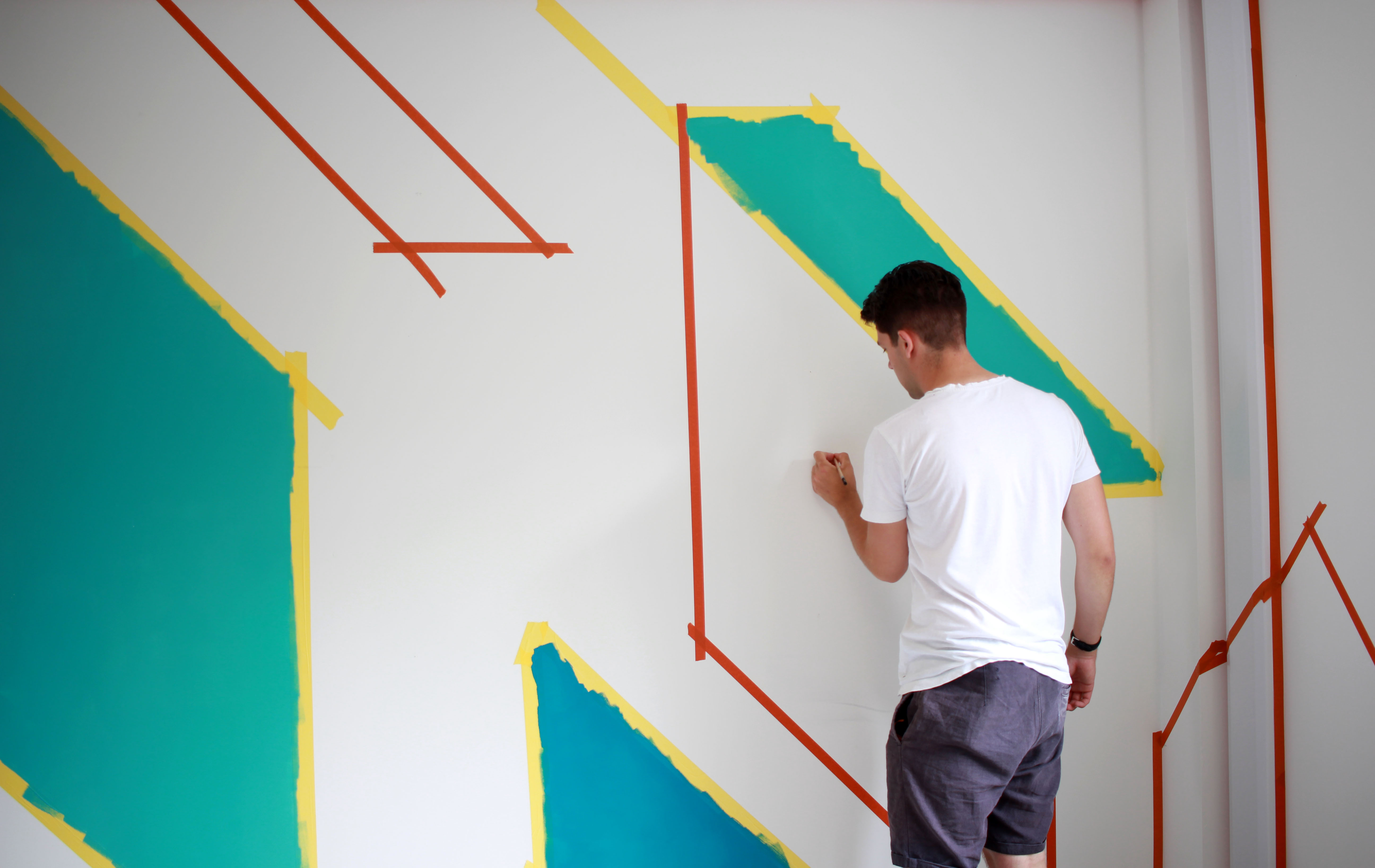 Artists hand-painting the mural on the office wall, ensuring consistency and quality in the artwork.