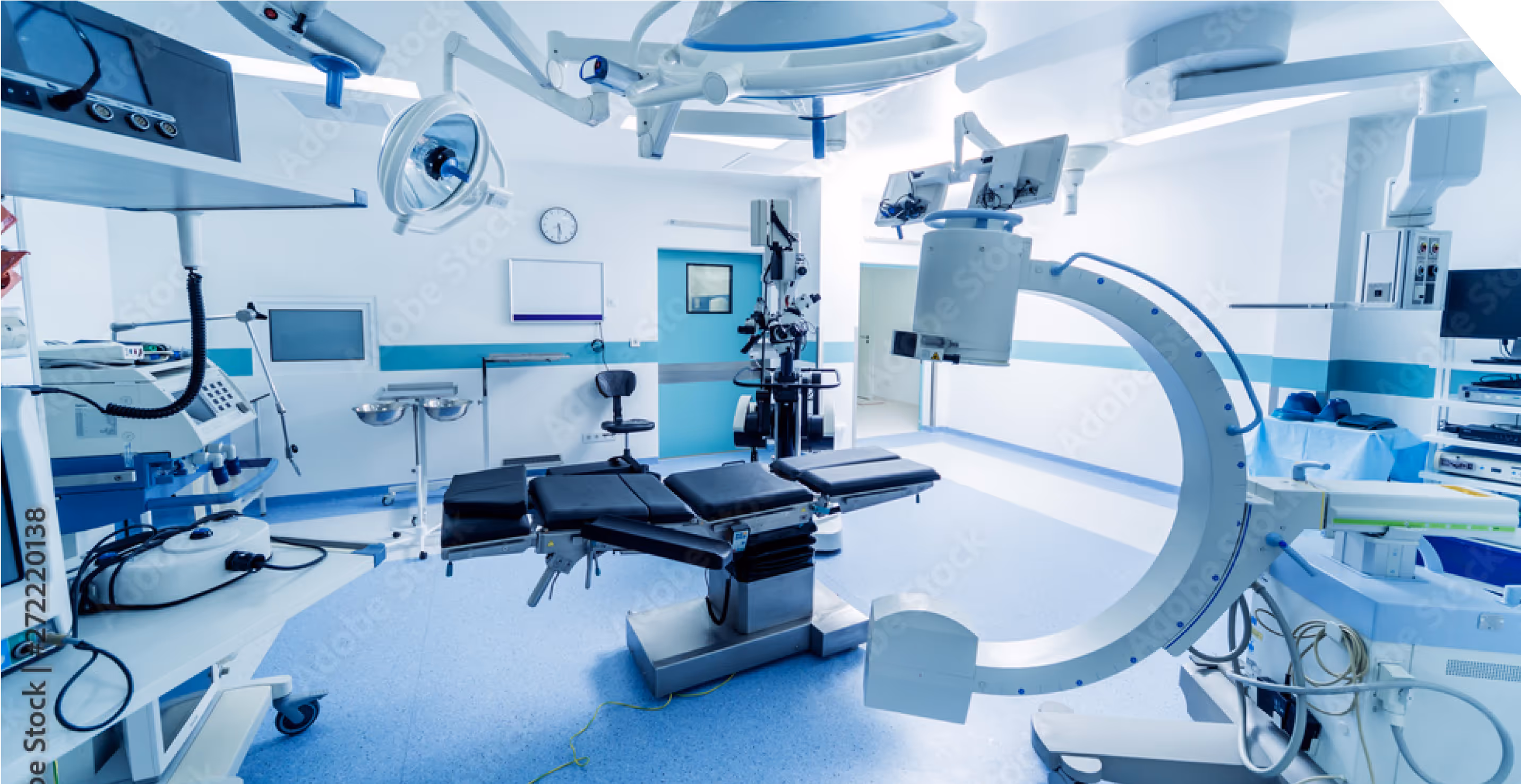 Empty operating room with modern surgical equipment, including an operating table and overhead lights.