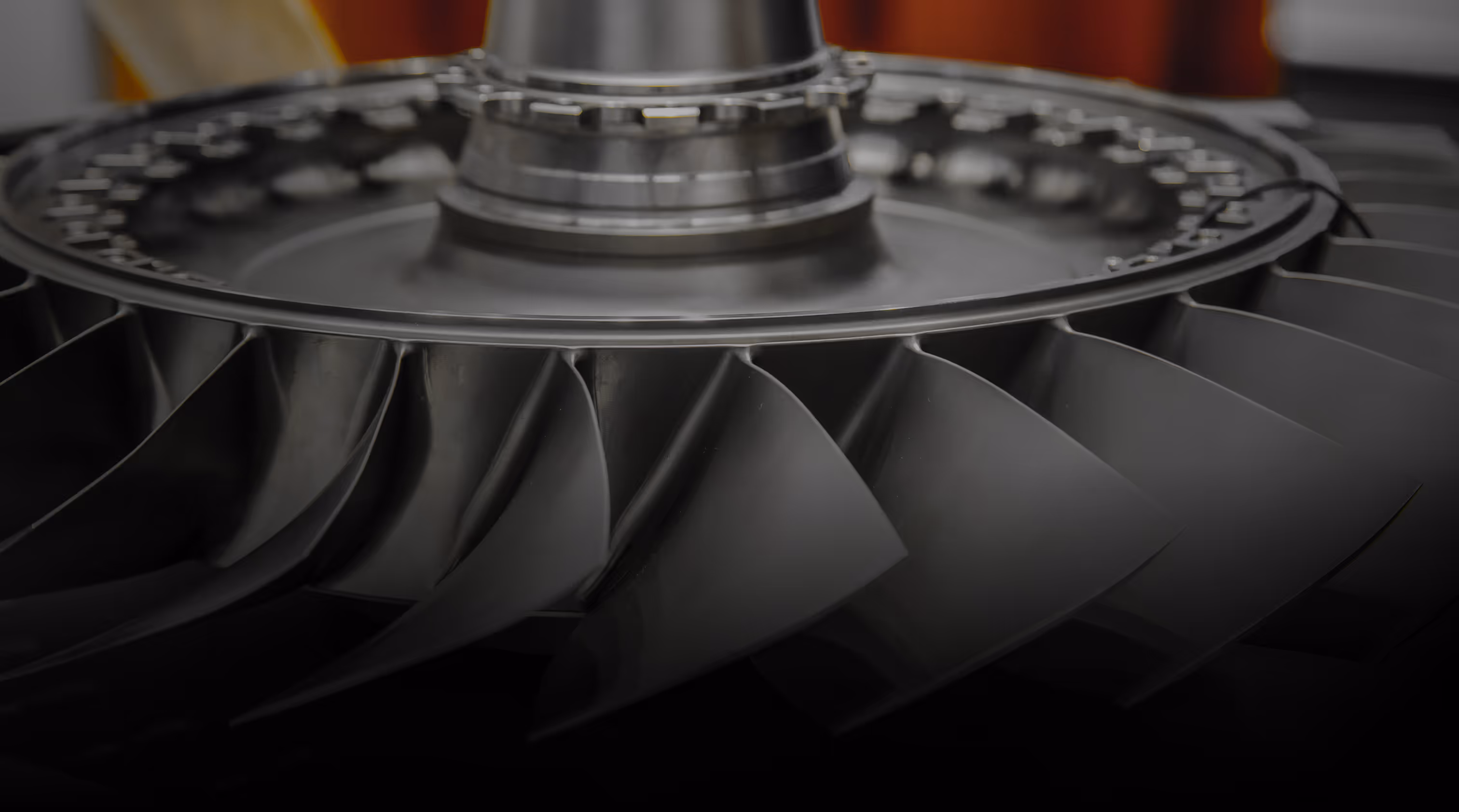 Close-up of a metal turbine blade assembly, with sharp, angled blades forming a circular pattern.