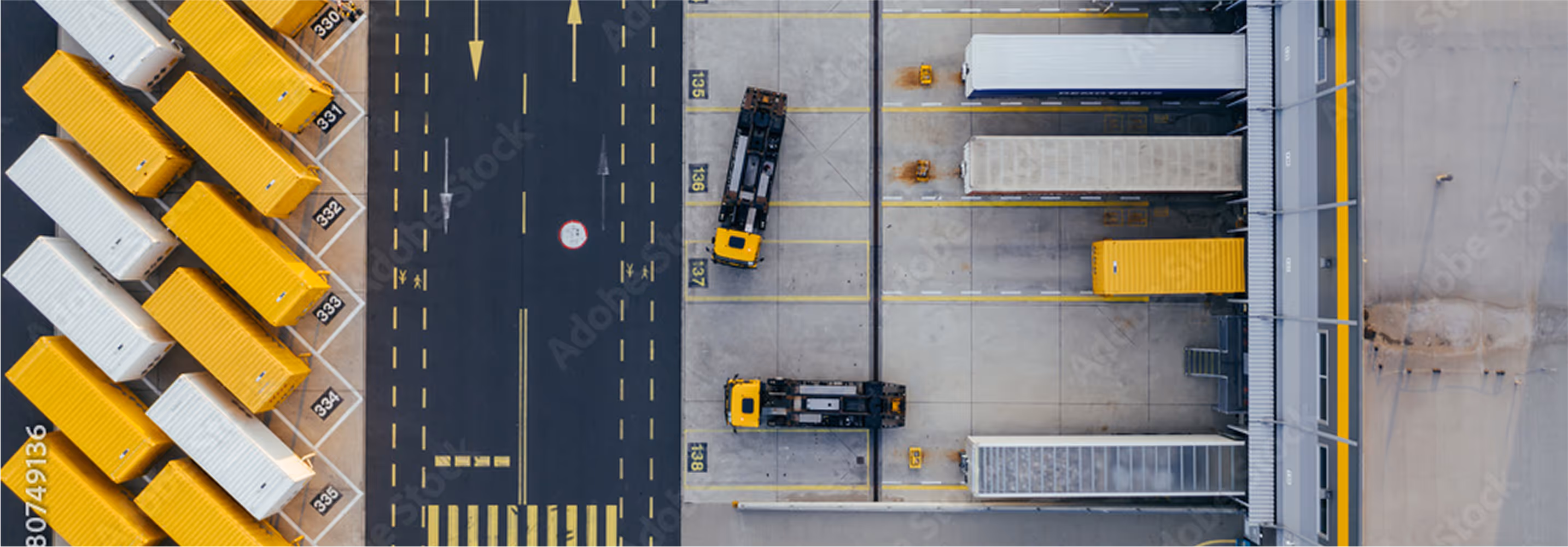 Aerial view of two trucks parked at dock doors, surrounded by yellow containers.