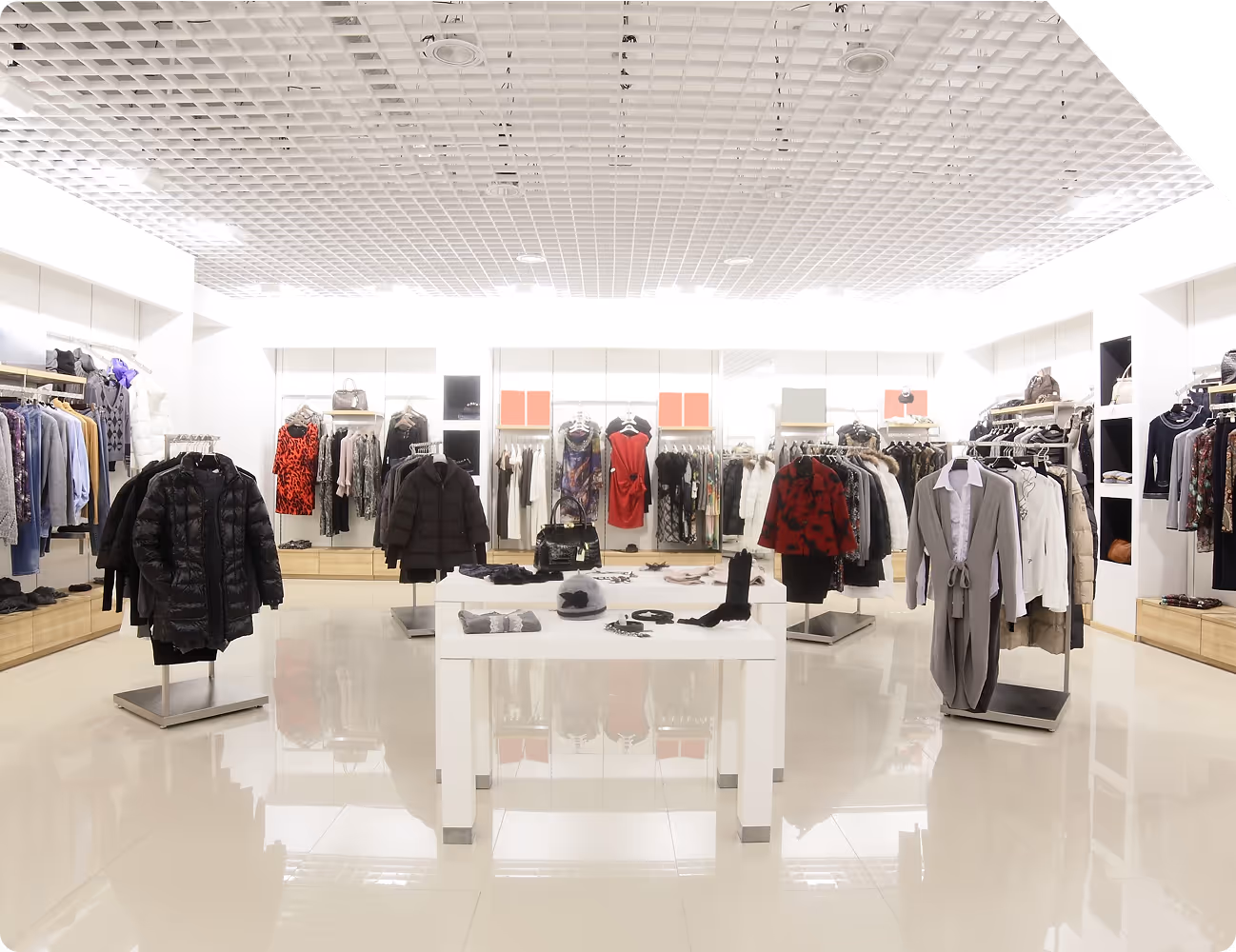 A brightly lit clothing store with various clothes and accessories displayed on racks and shelves.