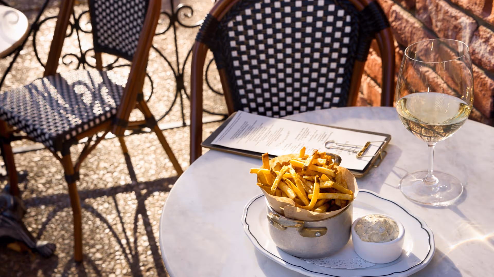 Photo of outdoor dining table with menu and french fries on the table