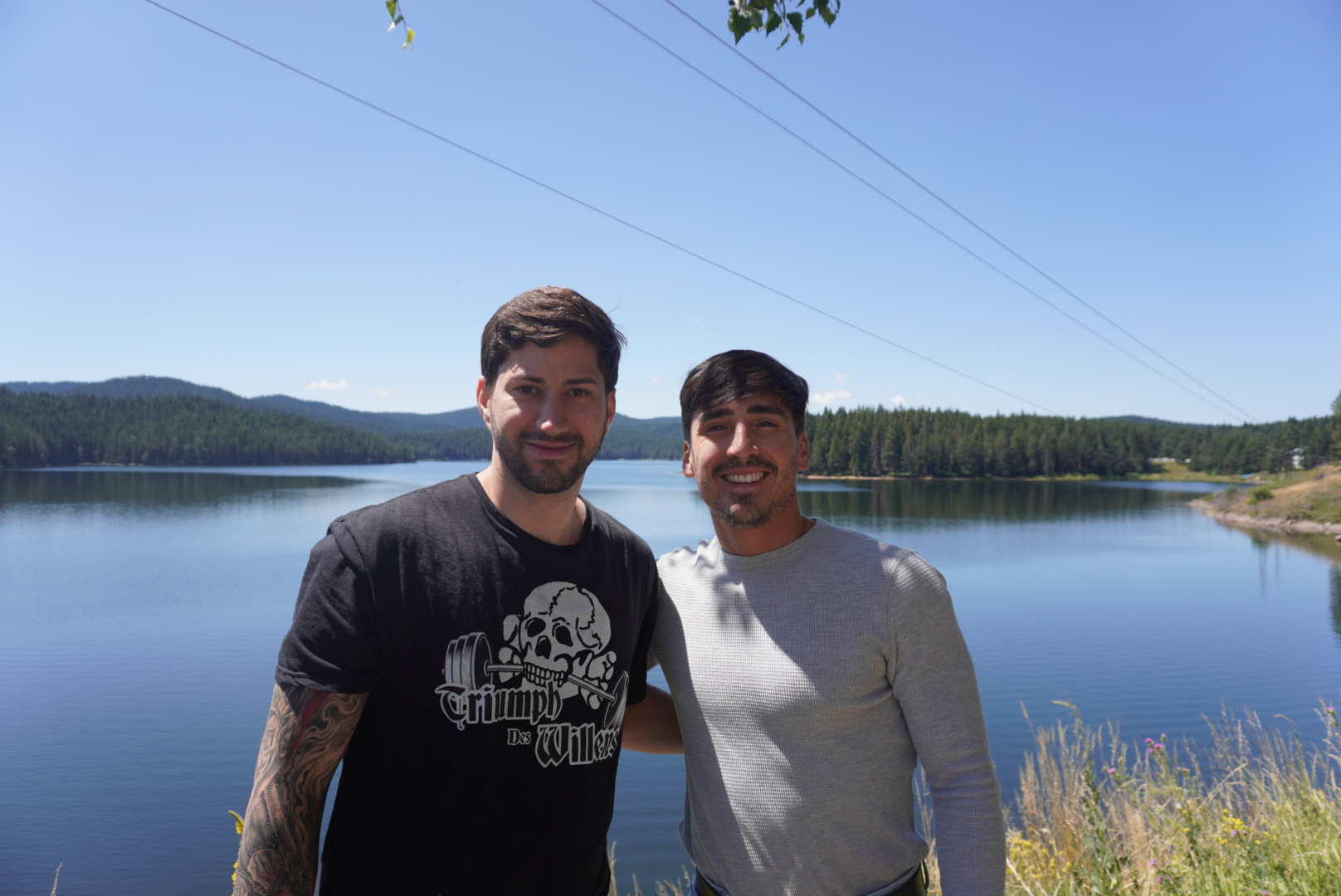 Two team members posing together by a lake