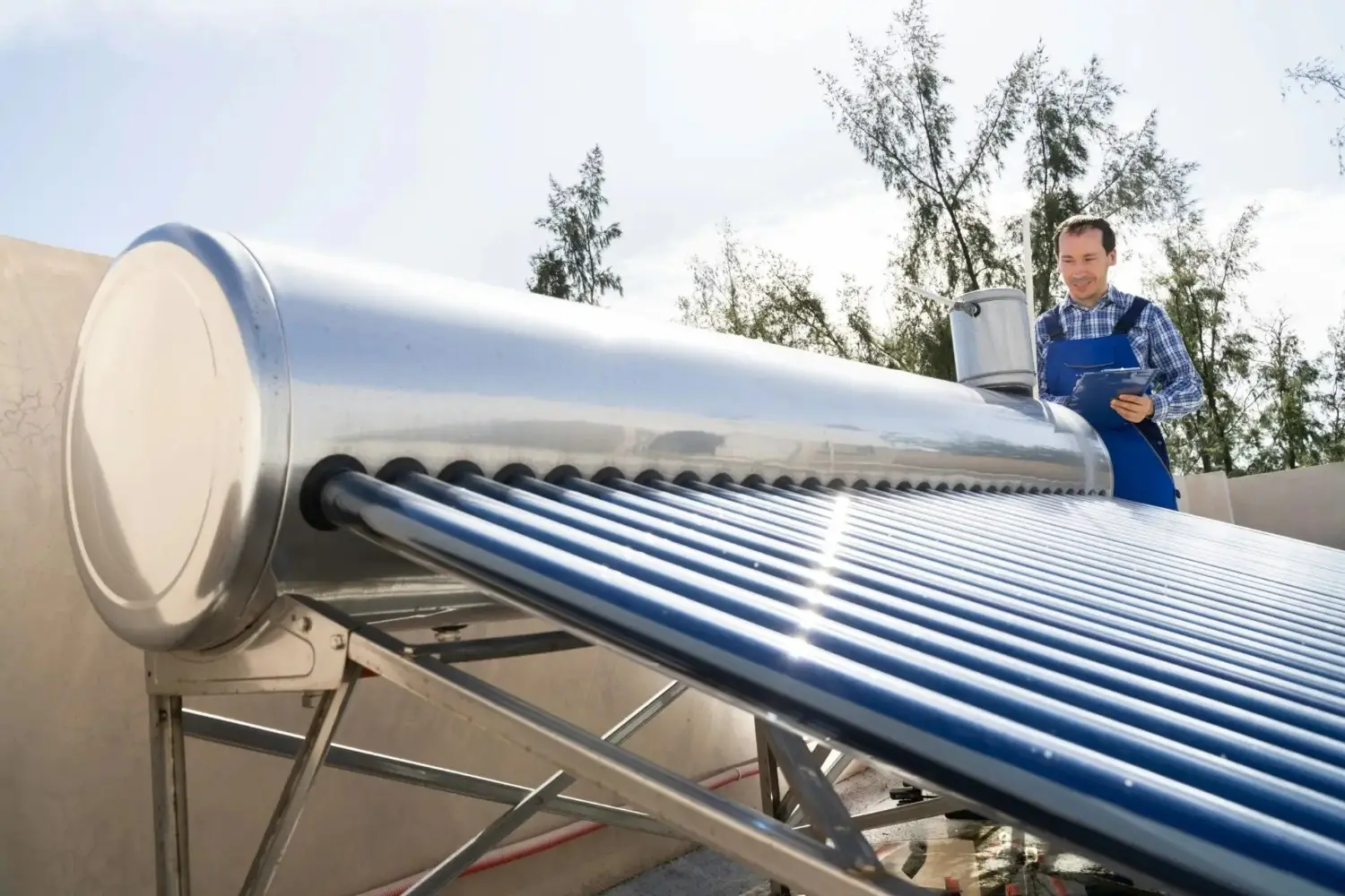 Technician in a uniform near solar water heater