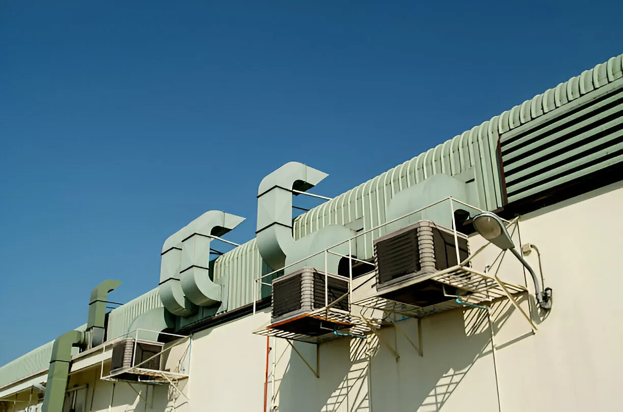 "Commercial evaporative coolers and ductwork on a building"