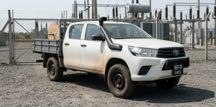 Picape com snorkel preto na coluna do para-brisa, em subestação de energia
