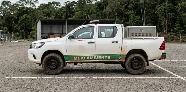 Picape de lado com faixa verde Meio Ambiente e logo Let's na porta
