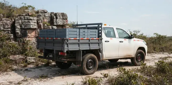 Picape vista de trás com pilhas de caixas de testemunho plásticas fechadas na carroceria de carga seca