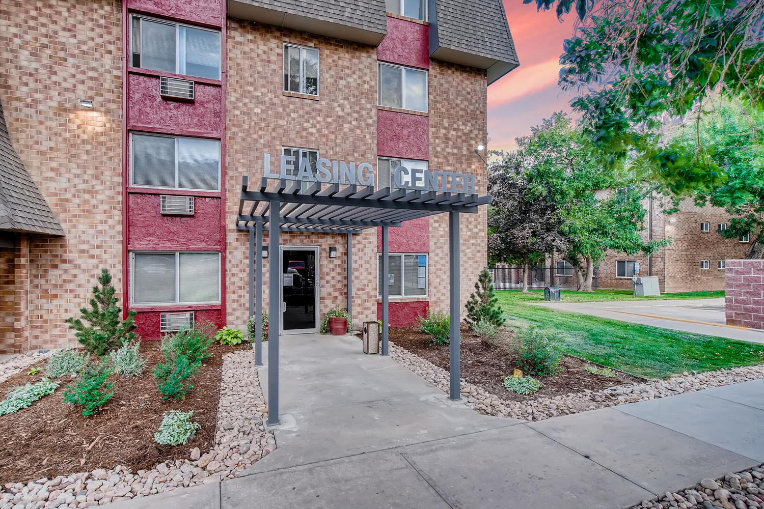 outdoor breeze way showing apartment doors and planters in between 