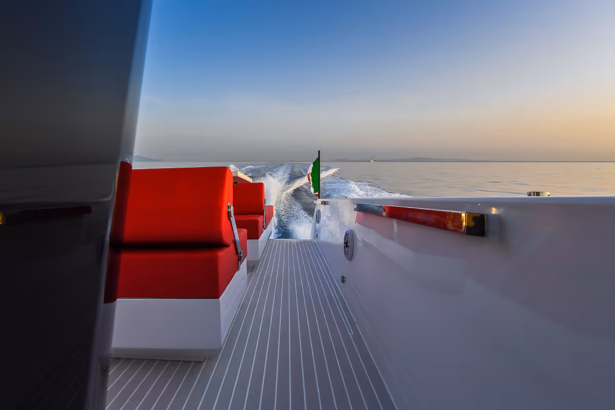 Fiart 43 Seawalker aft lounge area with red cushions and panoramic sea views, ideal for relaxing at sunset