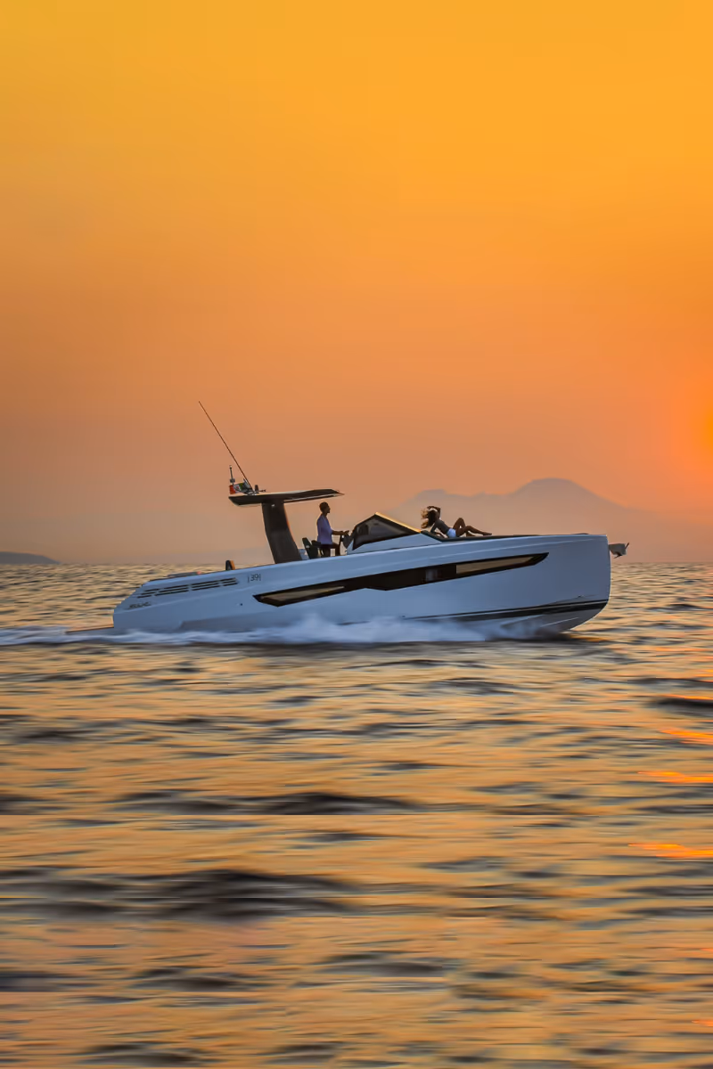 Exterior view of a Fiart Seawalker 39 charter motor yacht cruising seamlessly on open waters. at sunset with warm golden light during charter cruising