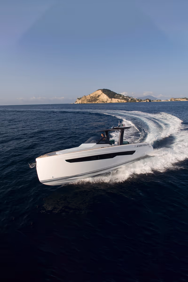 Exterior view of a Fiart Seawalker 39 charter motor yacht cruising seamlessly on open waters. at sunset with warm golden light during charter cruising