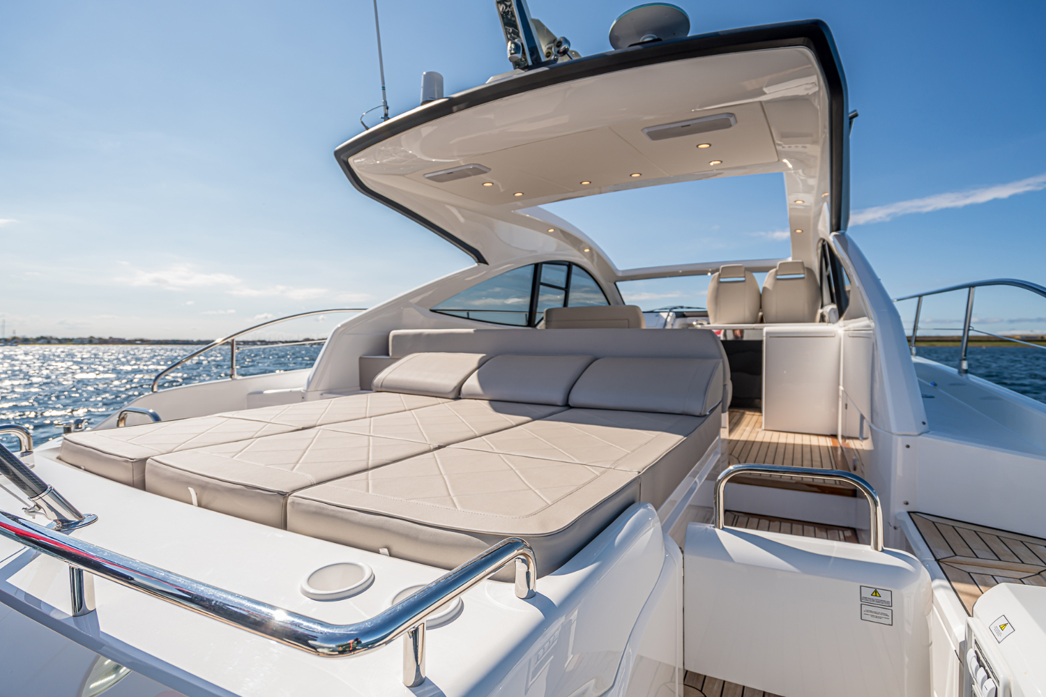 The lounge space of the Targa 50 Open charter, sunlit with inviting cushions and an open layout.