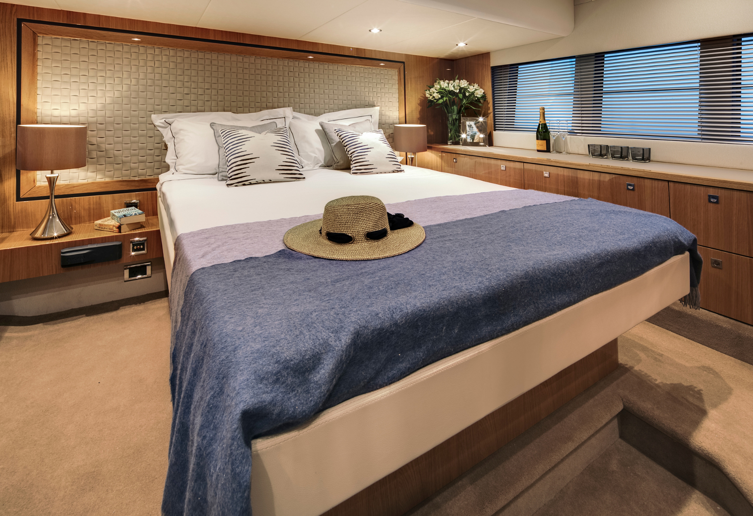The master cabin of the Targa 50 Open charter features elegant decor, a spacious bed, and ambient lighting.