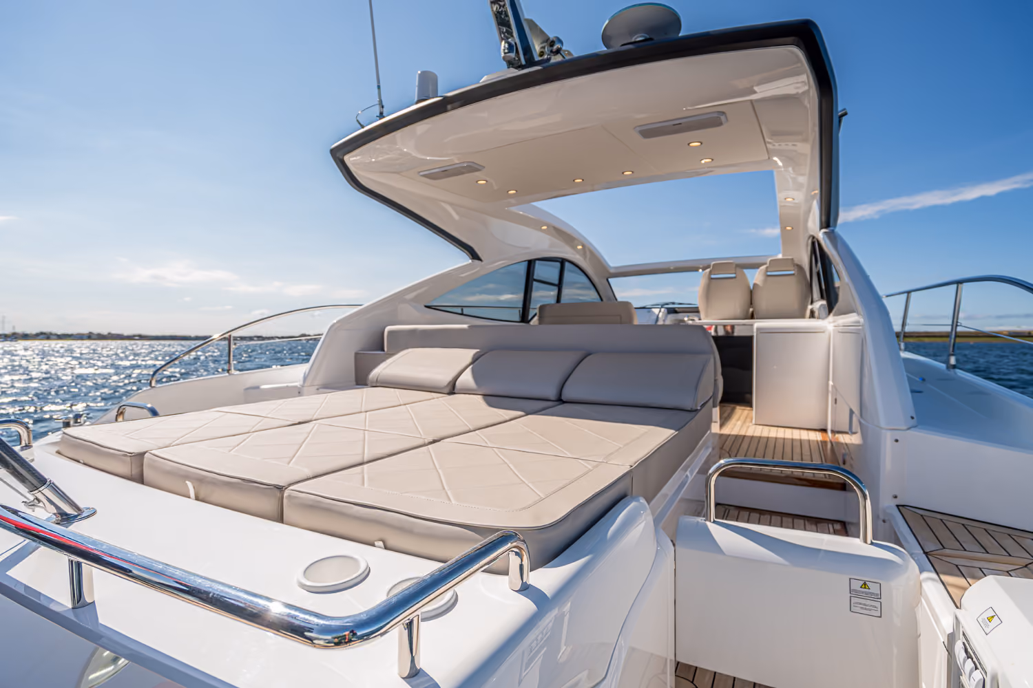 The lounge space of the Targa 50 Open charter, sunlit with inviting cushions and an open layout.