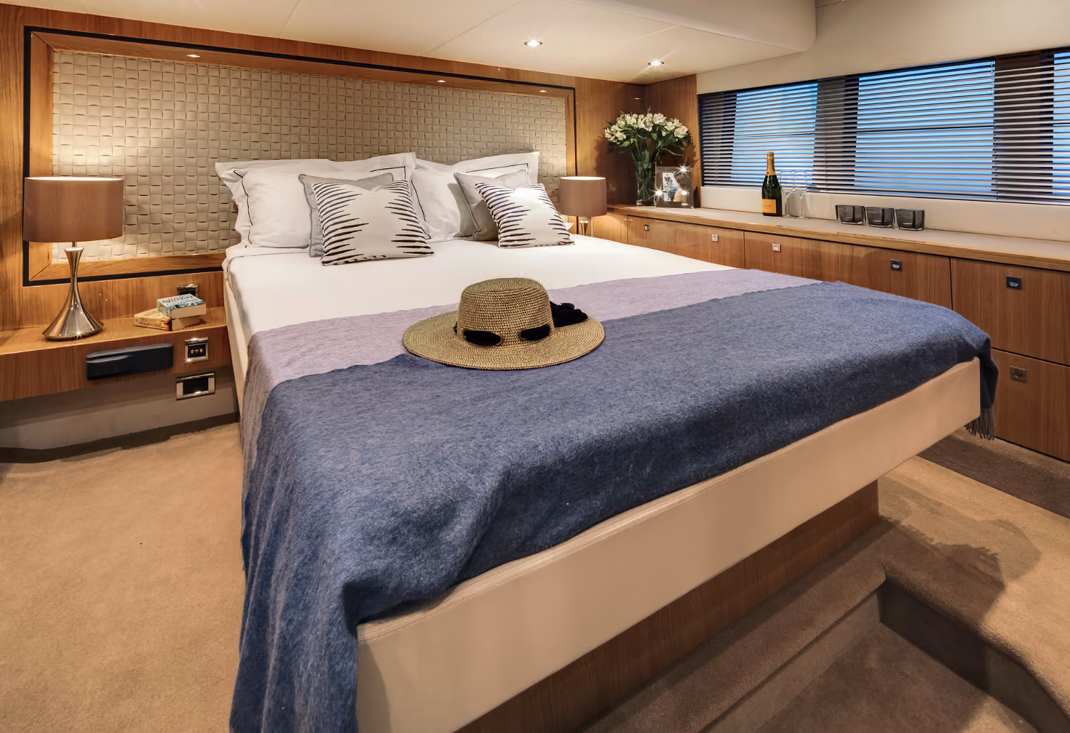 The master cabin of the Targa 50 Open charter features elegant decor, a spacious bed, and ambient lighting.