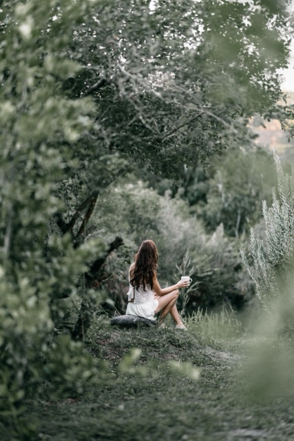 Femme assise dans la nature, illustration d’une approche douce et lente de la rencontre