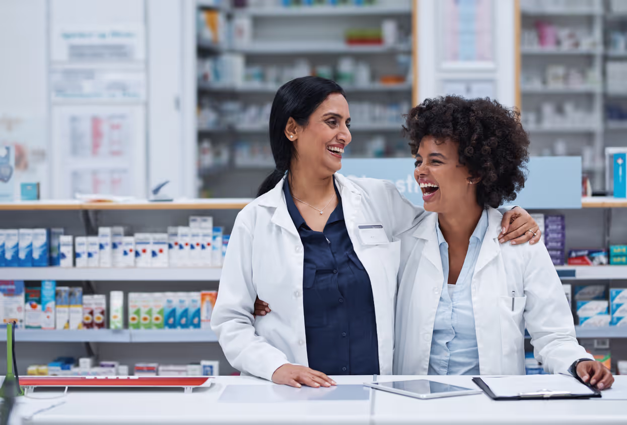 2 doctors hugging each other and laughing in a medical store