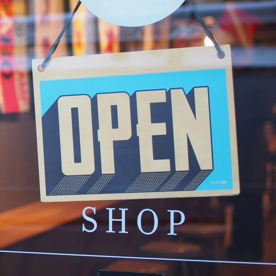 Open shop sign displayed in a window, showing the shop is now open