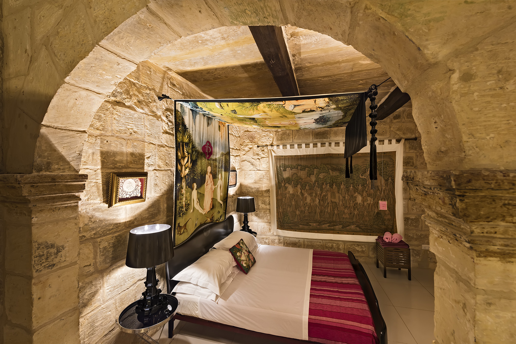 The bedroom in this historic Malta property was originally the house chapel and features a beautiful canopy picturing a scene from A Hieronymus Bosch painting. 