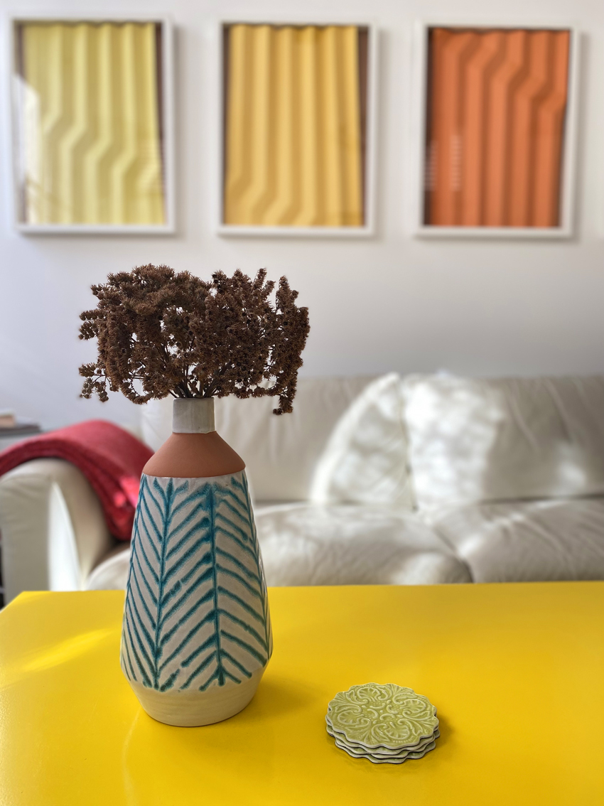 Vase on yellow bespoke coffee table in sitting room. 