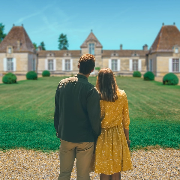 Un couple face à un chateau dans le vignoble de bordeaux
