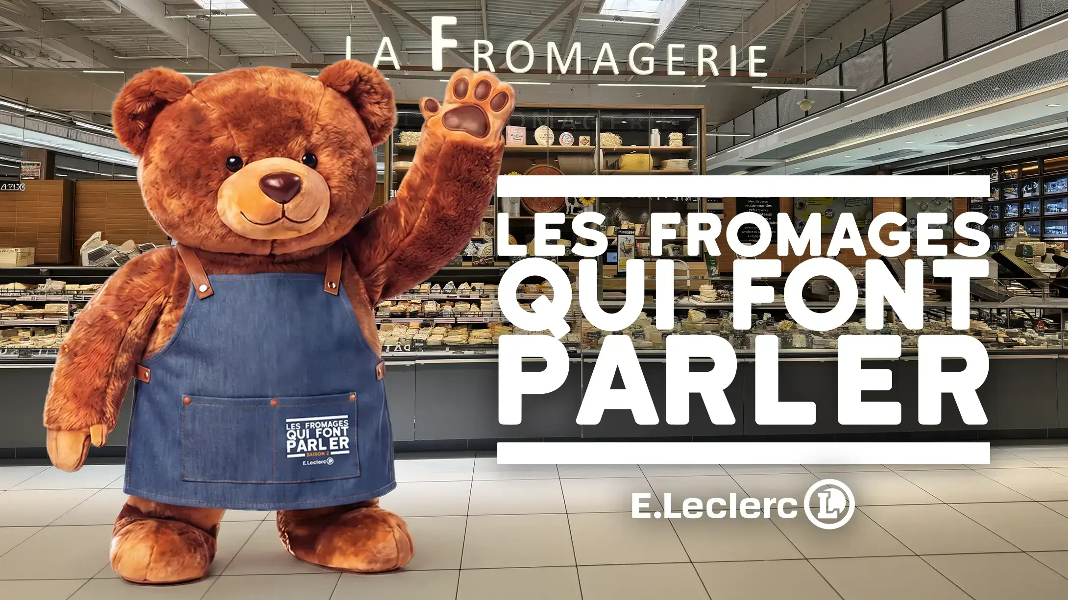 l'ours de la campagne qui salue, à côte du logo "les fromages qui font parler"