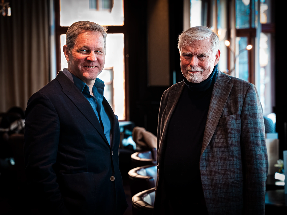 A picture of two men standing and looking straight at the camera.