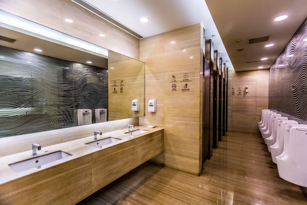 Modernes Sanitärgebäude mit Waschtischen und Urinalen, frisch gereinigt für hygienische Nutzung.