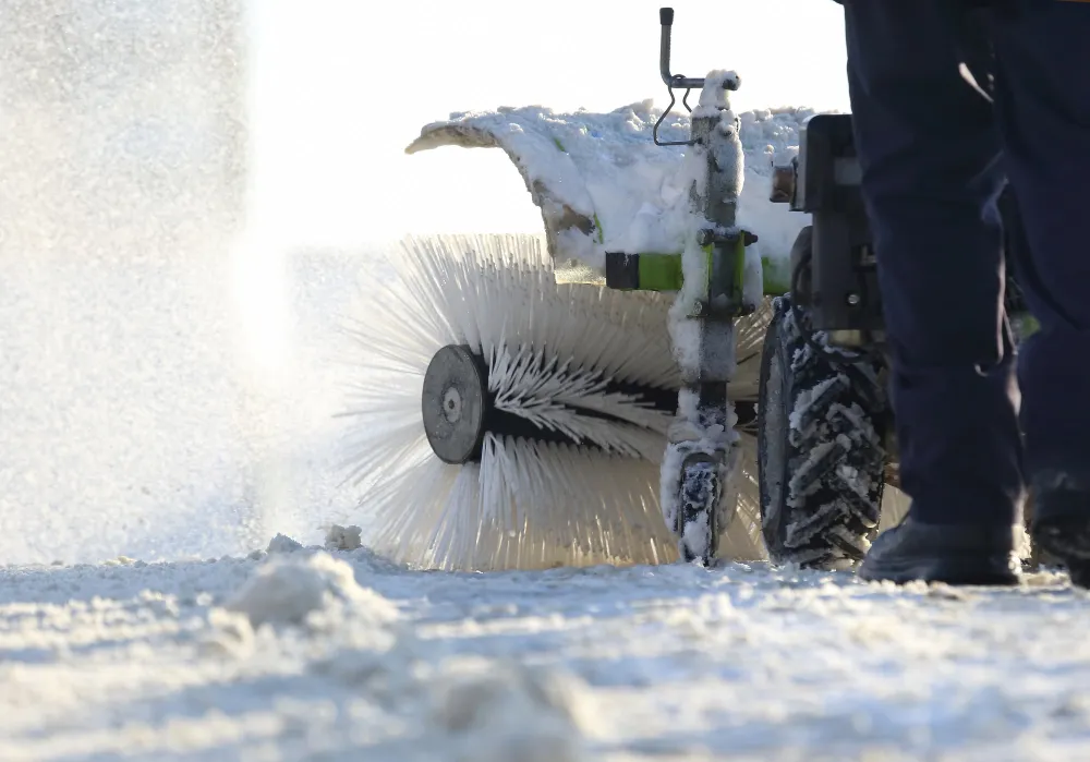 Schneefräse räumt Winterstraße mit großer Rundbürste
