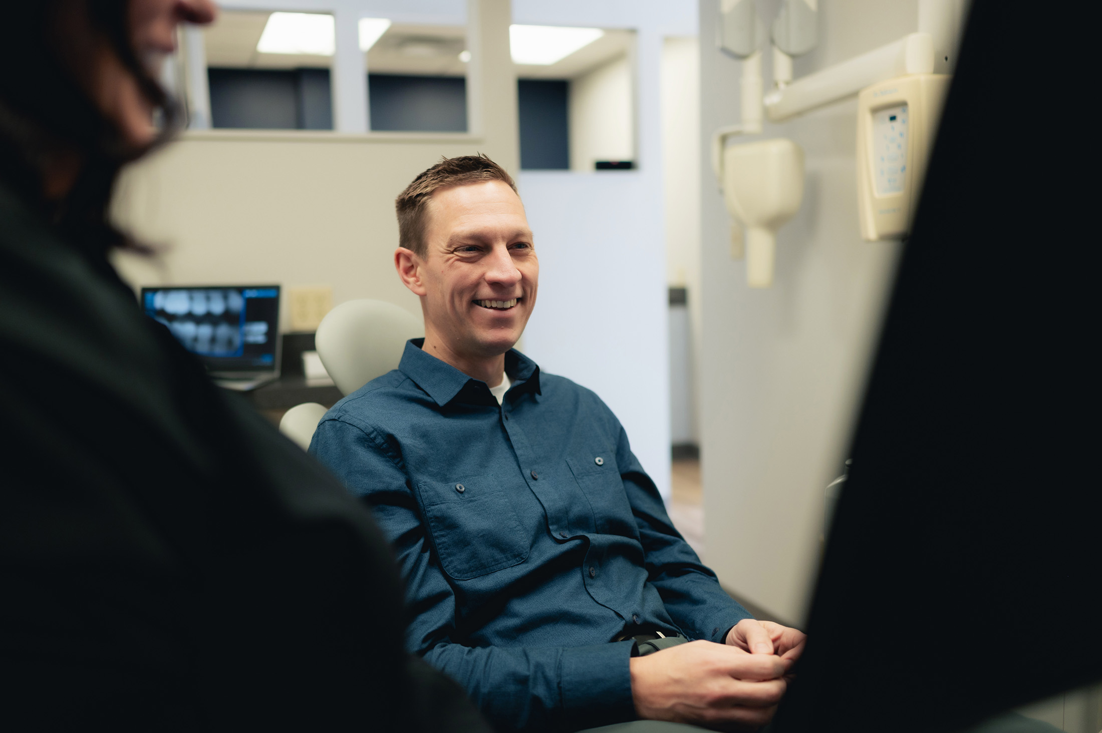 Photo of a male patient sitting in a chair smiling