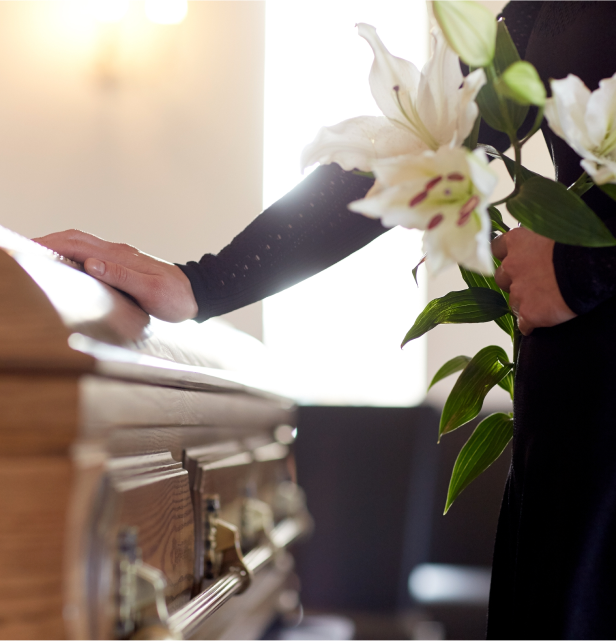 Mourning loved one with a gentle touch on the coffin.