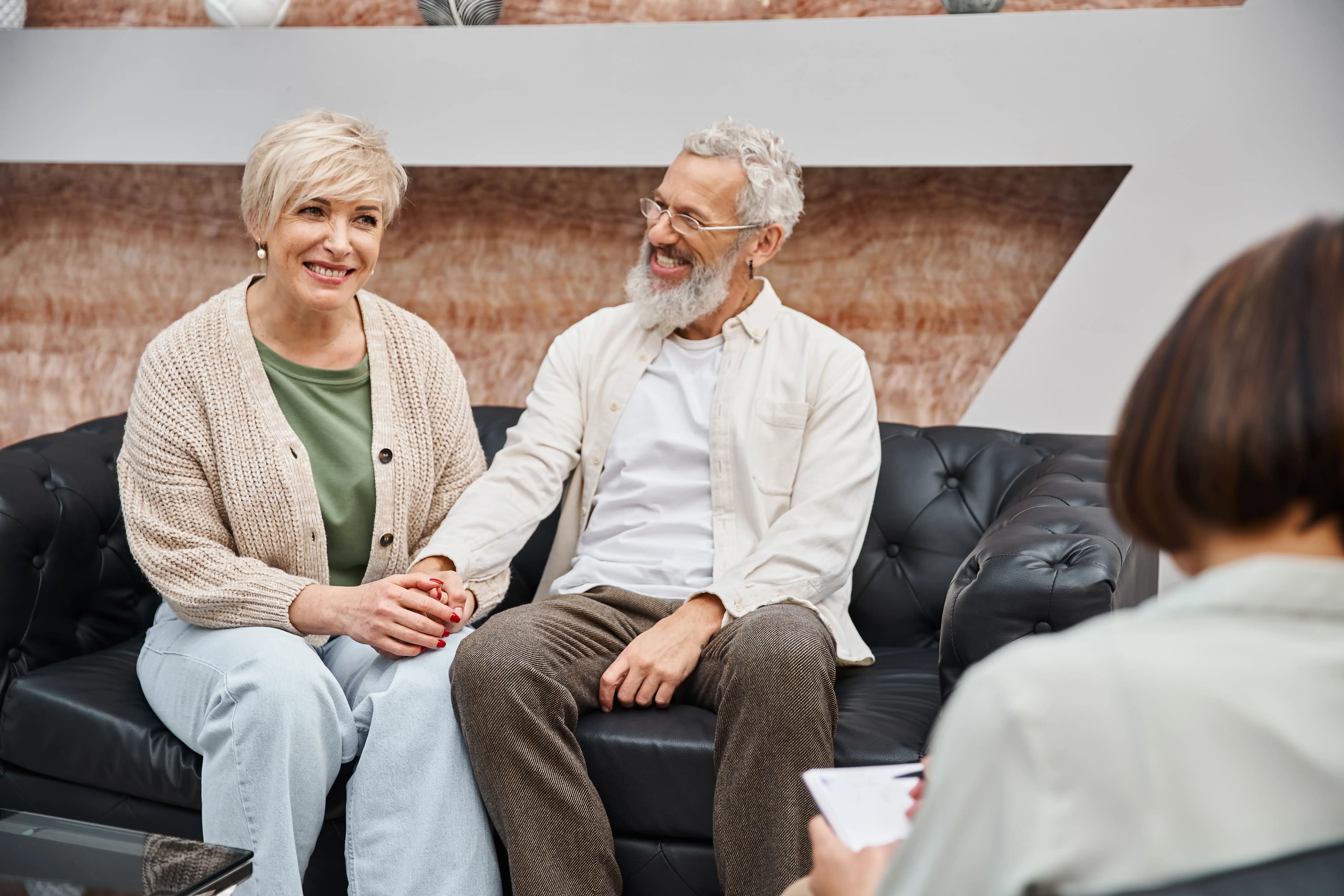 Elderly couple holding hands, symbolising care and support.