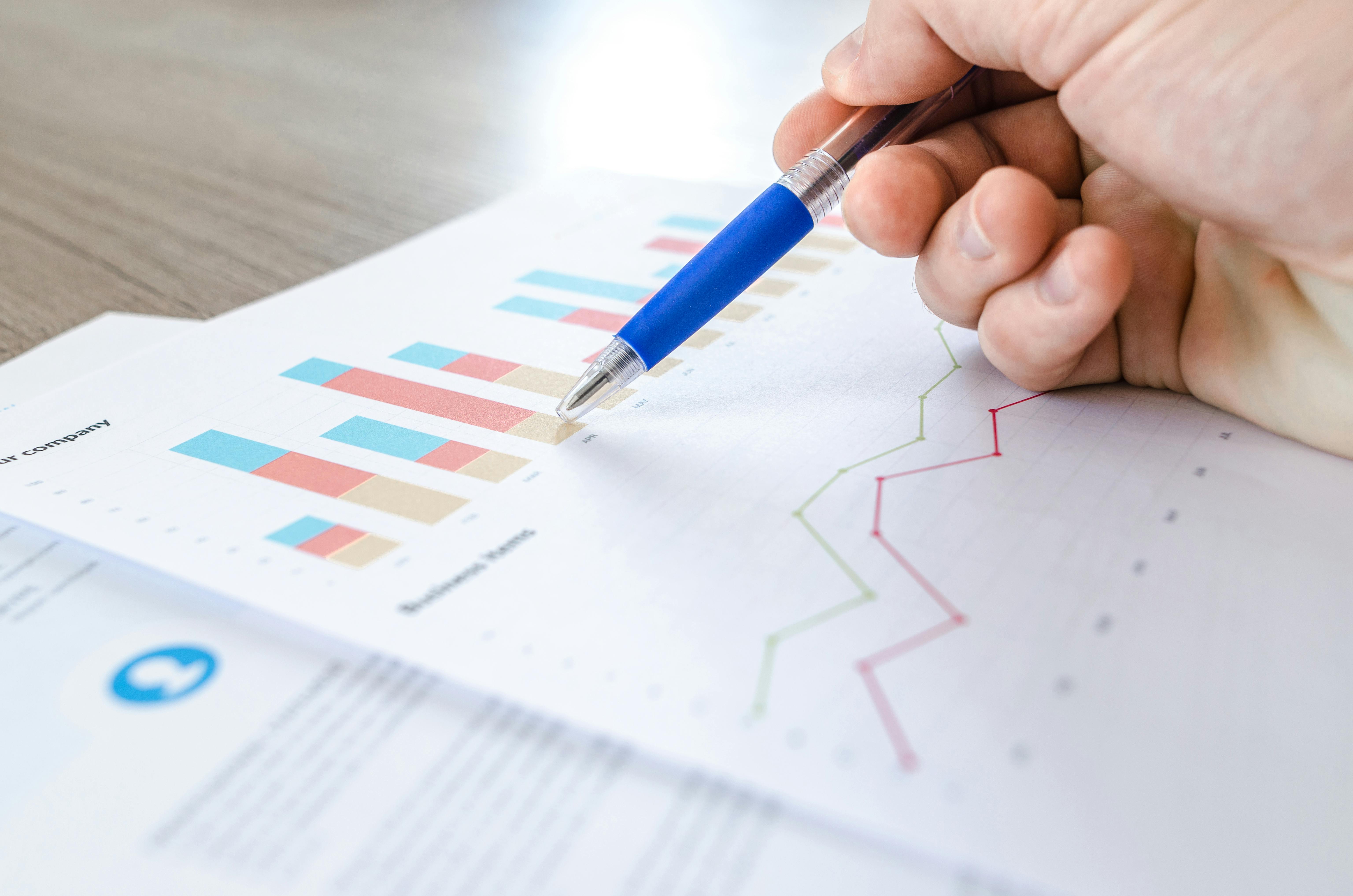 Hand analyzing data charts and graphs with pen