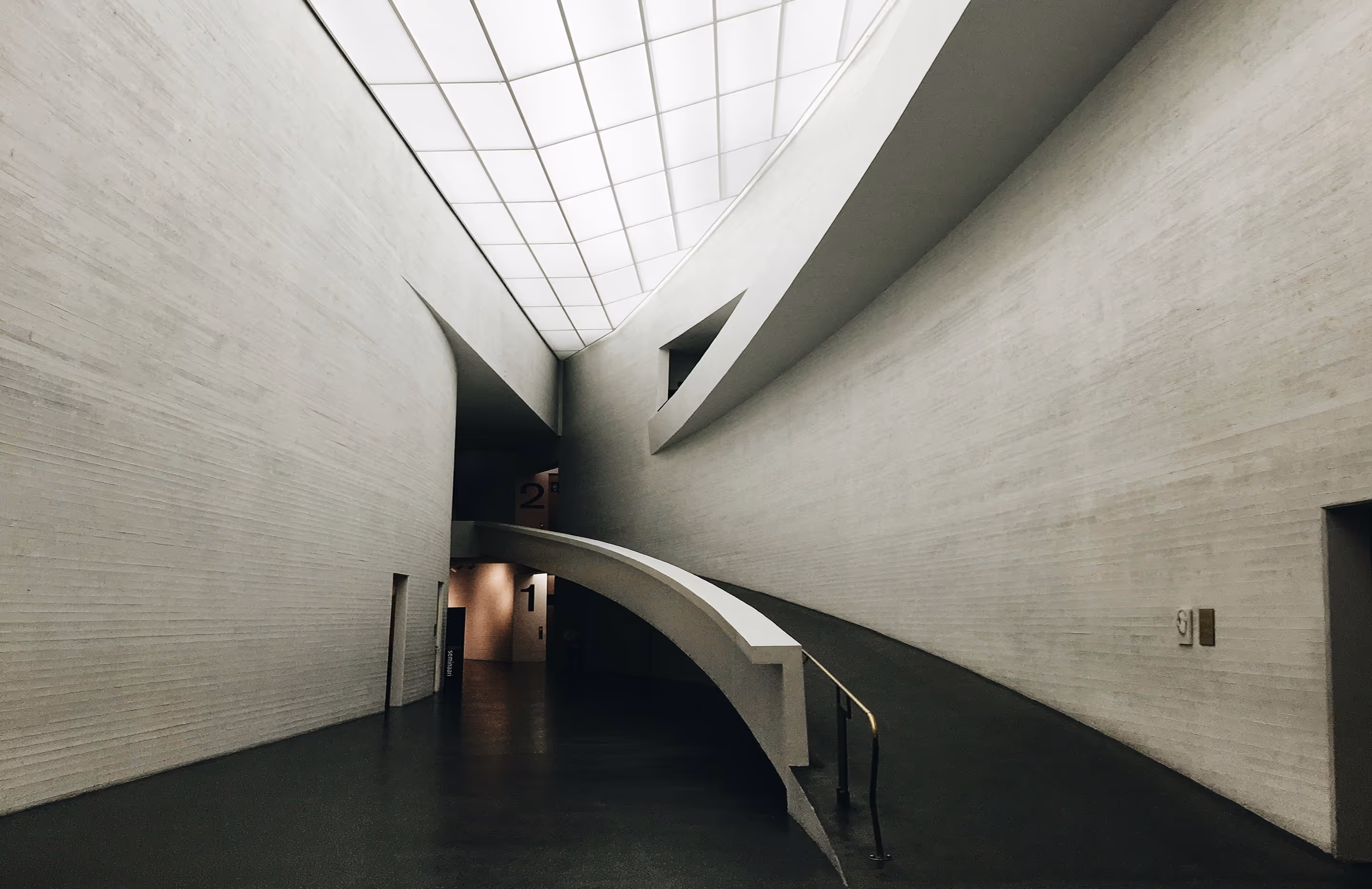 Futurisztikus belső tér íves betonszerkezettel és tejüveg mennyezettel