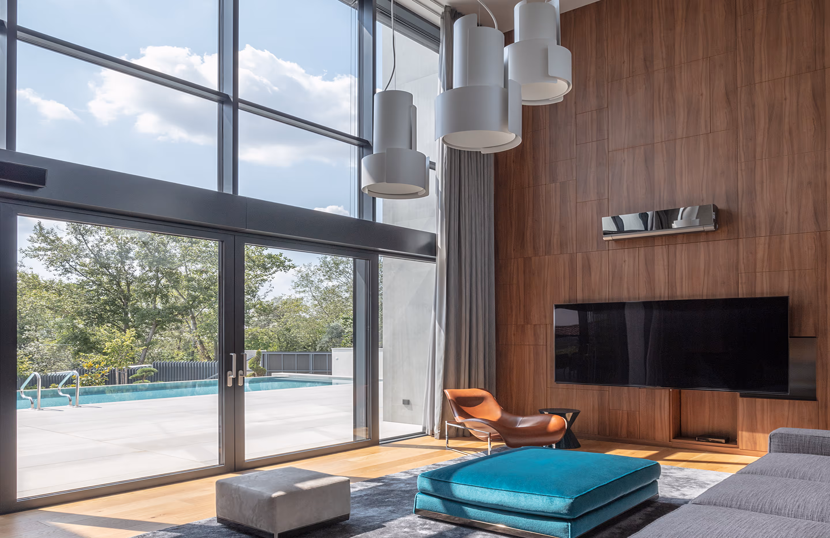 Elegant living room with large glass wall and views of the outdoor pool