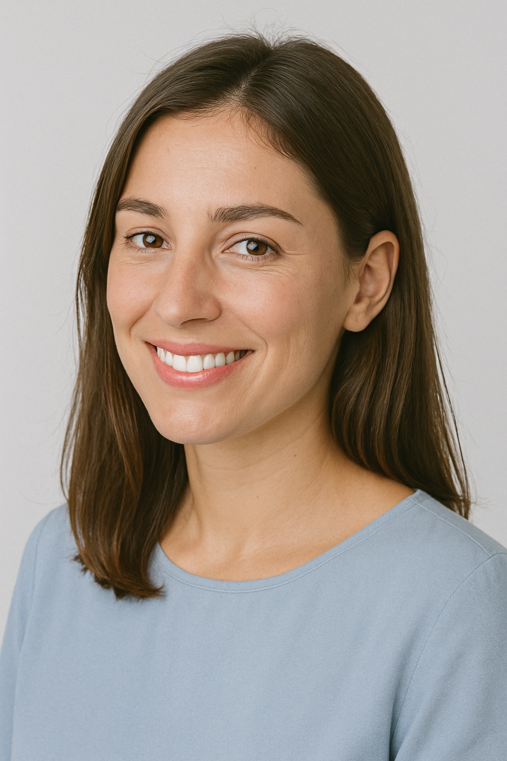 Smiling woman in light blue shirt against neutral background