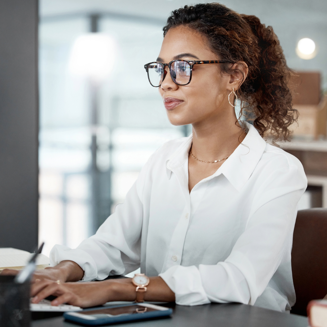 Professional woman with curly hair working on computer in office